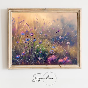 May include: A painting of a field of wildflowers in shades of blue, purple, and pink. The flowers are in focus, while the background is blurred and has a golden glow.