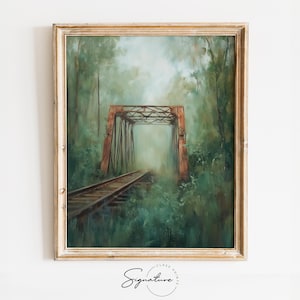 May include: A framed painting of a rusty metal bridge over a set of train tracks in a lush green forest. The bridge is partially obscured by the trees and the fog in the distance.