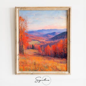 Puede incluir: Pintura de paisaje otoñal enmarcada. La obra representa un valle con árboles en tonos rojos y naranjas, colinas onduladas y un cielo azul. La pintura está firmada "Signature" en la esquina inferior izquierda.