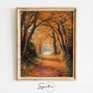 May include: A framed oil painting depicting a path through a forest in autumn. The trees are a vibrant orange and yellow, and the path is covered in fallen leaves. A small lake is visible in the distance.