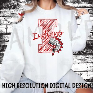 May include: White sweatshirt with a red and white graphic of a capital letter 'I' with the word 'Indians' above it. A red and white headdress is below the letter 'I'.