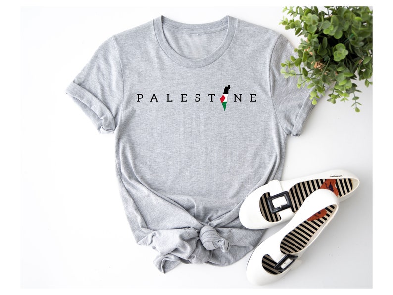 a t - shirt with the word palestine on it next to a pair of shoes