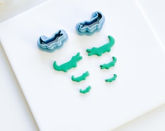 May include: A set of blue alligator cookie cutters and green fondant alligators of varying sizes.