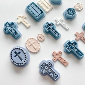 May include: Assortment of cross-shaped cookie cutters in various designs and colors, including blue, beige, and pink. Some crosses have floral or patterned details, while others are plain. Ideal for religious-themed baking.
