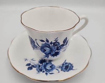Taza y platillo de té isabelino de Taylor & Kent, con rosas blancas y azules y ribete dorado.
