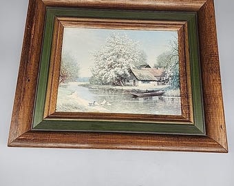 Pintura al óleo vintage de un paisaje de madera con un bosque, un río, una cabaña y un lago, enmarcada en 1953.