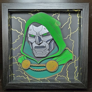 May include: A framed papercraft artwork of Doctor Doom, a Marvel Comics supervillain. The artwork features a green and gold color scheme with a detailed depiction of Doctor Doom's face and iconic helmet. The background is a black and gold pattern of lightning bolts.