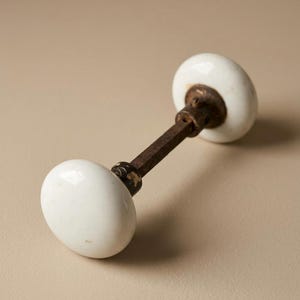 Può includere: Pomello per porta antico con maniglie bianche in ceramica a forma di uovo e un'asta di collegamento in metallo arrugginito. La ferramenta della porta è in stile vintage, perfetta per aggiungere un tocco di fascino classico a qualsiasi porta.