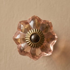 Pode incluir: Puxador de armário decorativo em vidro rosa com design floral. O puxador apresenta um centro de latão e um exterior facetado em forma de pétala. Adequado para gavetas, armários e móveis. Mede aproximadamente 4 cm de diâmetro.