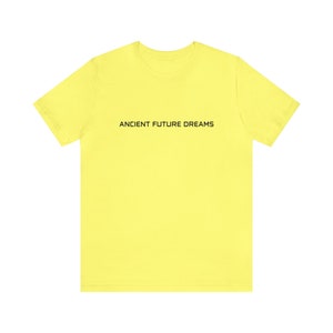 May include: A bright yellow t-shirt with the text "ANCIENT FUTURE DREAMS" printed in black on the front.