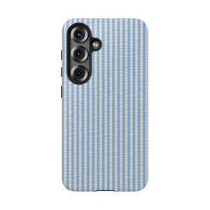 May include: A light blue and white striped phone case. The case has a vertical stripe pattern and a camera module with three lenses and a flash. The case is designed to fit a smartphone.