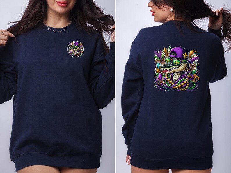 May include: A navy blue sweatshirt with a Mardi Gras alligator graphic on the back. The alligator is wearing sunglasses and a purple and gold hat. The front of the sweatshirt has a small, circular graphic of the alligator's head.