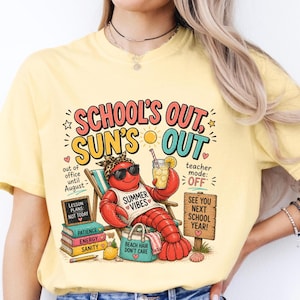 May include: Pale yellow t-shirt with a colourful graphic. A cartoon lobster in sunglasses is relaxing on a beach chair. Text includes "School's Out, Sun's Out" and "Summer Vibes". Other text includes "Teacher Mode: OFF".