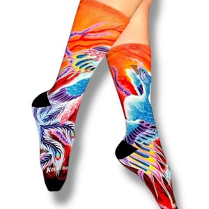May include: A pair of colorful socks with a blue and purple phoenix design on a red and orange background. The socks are knee-high and have a black toe and heel.