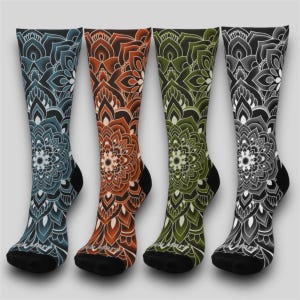 Puede incluir: Cuatro pares de calcetines coloridos con un diseño de mandala. Los calcetines son en tonos azul, naranja, verde y gris.