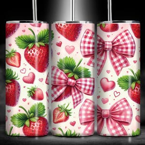 May include: A white tumbler with a pink and red pattern of strawberries, bows, and hearts. The tumbler is made of stainless steel and has a straw.