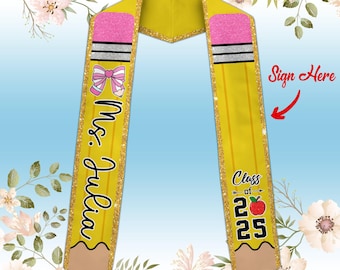 May include: Yellow pencil-shaped graduation sash with gold glitter trim. The sash has a pink bow and the text "Mrs. Julia" on one side and "Class of 2025" with a red apple on the other side. The sash has a blank space for a signature.