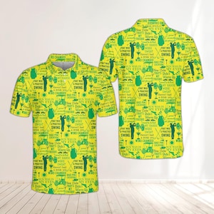 May include: Yellow golf polo shirt with a repeating green pattern of golf-related phrases and graphics. The design includes golf carts, golf clubs, and text like "Swing" and "My Eyes."