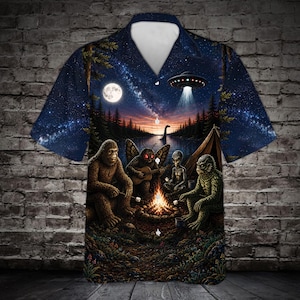 May include: A short-sleeve button-down shirt featuring a dark night sky print with a full moon, a flying saucer, and a campfire scene. The graphic depicts Bigfoot, a moth-like creature playing guitar, an alien, and a swamp monster roasting marshmallows.