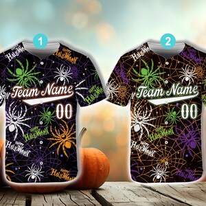 May include: Two Halloween-themed baseball jerseys. One is black with green, white, and orange spiders and webs. The other is brown with green, purple, and white spiders and webs. Both have "Team Name" and "00" on the front.