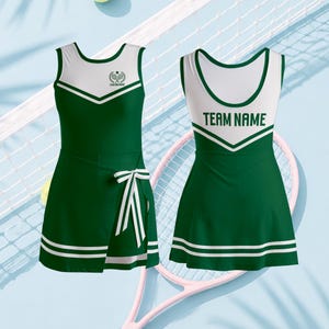 Könnte beinhalten: Zwei dunkelgrüne und weiße Sportkleider mit ärmellosem Design und V-Ausschnitt. Das linke Kleid hat einen Wickelrock mit Bindeband und ein Tennisschläger-Logo mit dem Text CUSTOM NAME. Das rechte Kleid zeigt den Schriftzug TEAM NAME.