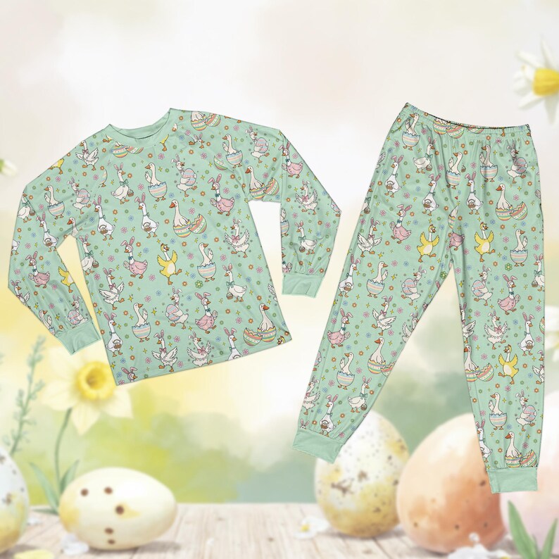 May include: A two-piece pajama set featuring a light green background with a repeating pattern of cartoon geese wearing Easter-themed accessories. The long-sleeved top and pants have matching cuffs and a whimsical design.