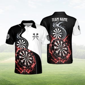 Op de afbeelding: Een zwart-wit poloshirt met een dartbordontwerp. Het shirt heeft een dartbordafbeelding met rode vlammen en de tekst "YOUR NAME" op de voorkant en "TEAM NAME" op de achterkant. Het shirt heeft korte mouwen.