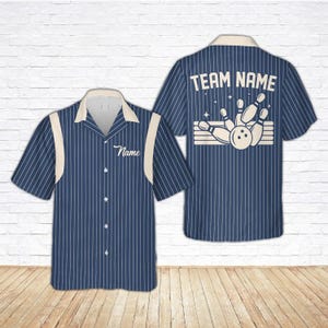 May include: Navy blue bowling shirt with white vertical stripes and a cream-coloured collar and accents. The front has a space for a name, and the back features a bowling pin graphic and the text "TEAM NAME".