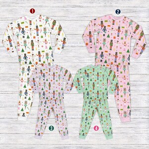 May include: Four sets of children's pajamas with a festive holiday theme. The pajamas feature a repeating pattern of nutcrackers, Christmas trees, and ballerinas. The sets are in white, pink, lavender, and green.