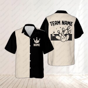 May include: A bowling-themed button-up shirt with a black and cream color block design. The front features a bowling pin graphic and the word "NAME". The back displays "TEAM NAME" above a bowling ball and pins graphic.