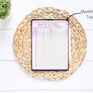 May include: A monthly sleep tracker with a purple and white gradient background. The tracker has columns for the date, hours slept, sleep quality, and type of dream. The tracker is on a woven mat.