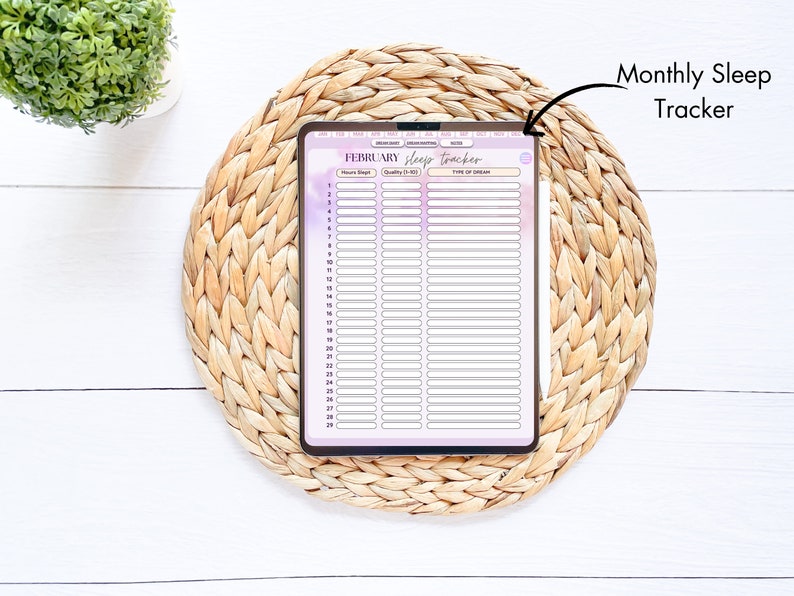 May include: A monthly sleep tracker with a purple and white gradient background. The tracker has columns for the date, hours slept, sleep quality, and type of dream. The tracker is on a woven mat.