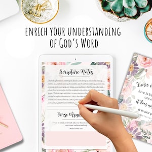 May include: A digital tablet with a pink floral design and the text "Scripture Notes" and "Verse Application". The text on the tablet reads "Trust in the Lord with all your heart and lean not on your own understanding. Proverbs 3:5". A hand is holding a stylus and writing on the tablet. A pink notebook with the text "My Bible" is in the background. A second notebook with a pink floral design and the text "Love is patient. Love is kind. It does not envy. It does not boast. It is not proud. 1 Corinthians 13:4" is also in the background.