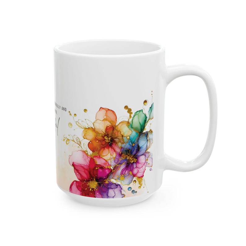 May include: White ceramic mug with a colorful floral design. The flowers are painted in shades of pink, purple, blue, green, and yellow. The text "Beautifully and wonderfully" is printed on the mug.
