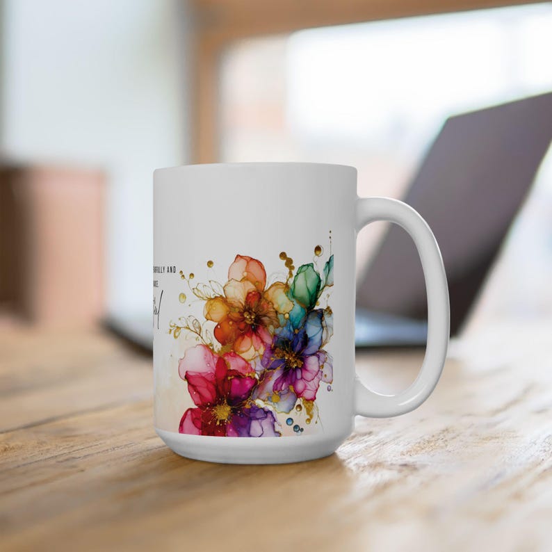 May include: White ceramic mug with a colorful floral design and the text "Beautifully and wonderfully made." The flowers are painted in shades of pink, purple, blue, green, orange, and yellow with gold accents.
