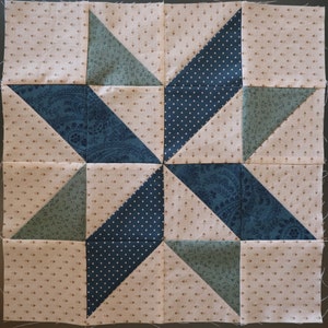 May include: A quilt block with a star design in shades of blue and green on a beige background. The star is made up of triangles and squares.