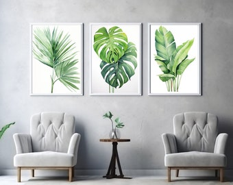 May include: Three framed watercolour paintings of tropical leaves. The paintings are in white frames and are hung on a grey wall. Two white armchairs are placed in front of the paintings, and a small wooden table with a vase of green plants sits between the chairs.