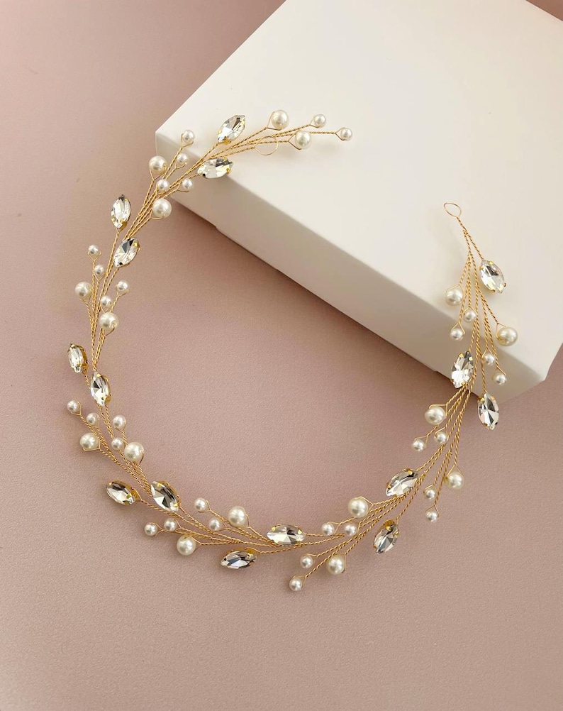 May include: A gold hair vine with pearl and crystal accents. The vine is flexible and can be styled in a variety of ways.