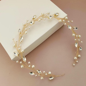 May include: A gold bridal hair vine with small white pearls and clear rhinestones. The vine is flexible and can be shaped to fit any hairstyle.