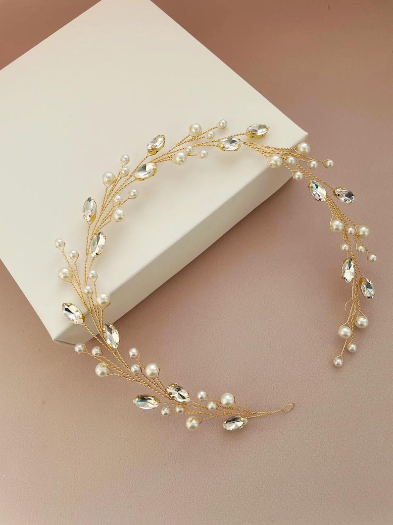 May include: A gold bridal hair vine with small white pearls and clear rhinestones. The vine is flexible and can be shaped to fit any hairstyle.