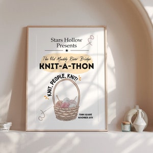 Könnte beinhalten: Ein gerahmtes Poster mit dem Text "Stars Hollow Presents KNIT-A-THON" und einer Illustration eines Korbes voller Garn. Das Poster wird auf einem weißen Regal mit dekorativen Gegenständen ausgestellt.