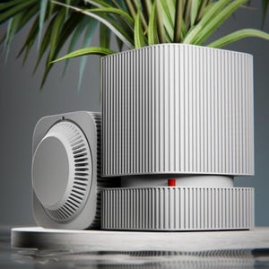 May include: A light gray, vertically ribbed square planter containing a green palm plant, positioned next to a matching square device with a circular, ribbed dial on its side. A small, bright red cylindrical indicator is visible on the planter base.
