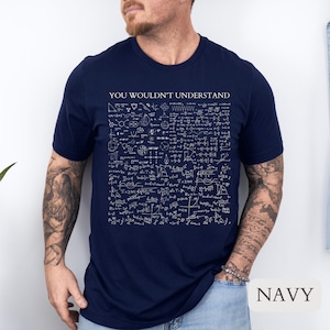 Könnte beinhalten: Ein marineblaues T-Shirt mit dem Text "YOU WOULDN'T UNDERSTAND" auf der Vorderseite. Das Shirt ist mit einer Vielzahl von mathematischen Gleichungen und Symbolen bedeckt.