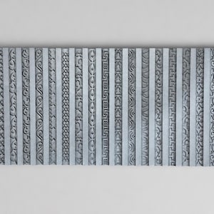 Puede incluir: Un molde rectangular de silicona gris que presenta veintiuna tiras verticales distintas, cada una grabada con un patrón repetitivo único que incluye grecas geométricas, motivos florales, diseños de ondas y texturas de volutas intrincadas.