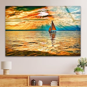 Puede incluir: Un velero con una vela marrón navega por un cuerpo de agua tranquilo. El sol se está poniendo, proyectando un cálido resplandor naranja en las nubes y reflejándose en la superficie del agua.