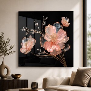 May include: A square wall art piece featuring a black background with translucent, light pink flowers and thin, metallic gold stems. The floral arrangement is accented with small, clear, spherical beads attached to delicate, branching gold wires.