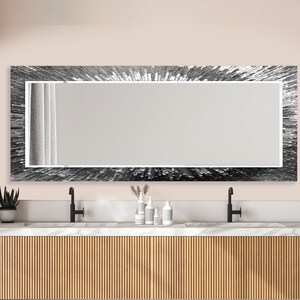 a bathroom vanity with a large mirror above it