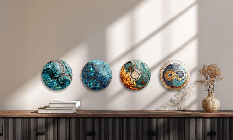 four circular wall art pieces with unique designs, displayed on a wall above a wooden shelf with books and a vase.