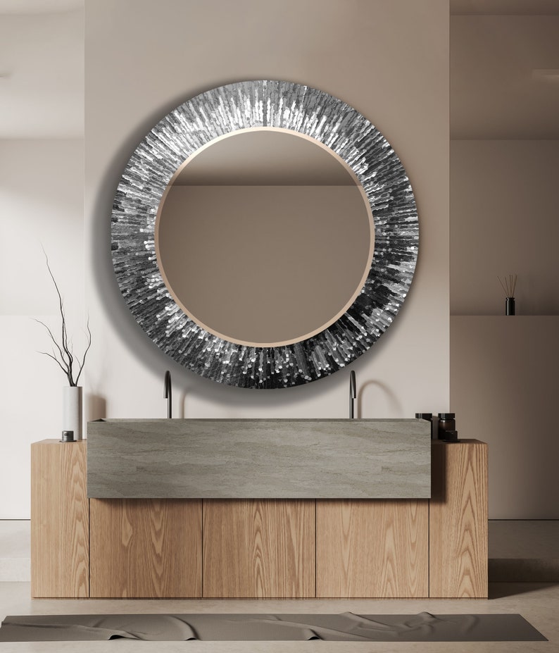 a bathroom vanity with a round mirror above it