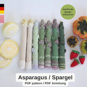 Könnte beinhalten: Eine Sammlung gehäkelter Lebensmittel, bestehend aus drei gelben Zitronenscheiben, sieben Spargelstangen in Weiß- und Grüntönen, zwei orangefarbenen und grünen Paprika, einem kleinen dunklen runden Teil und drei roten Erdbeeren mit grünem Blatt.